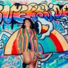 a woman in colorful shirt leaning on the wall