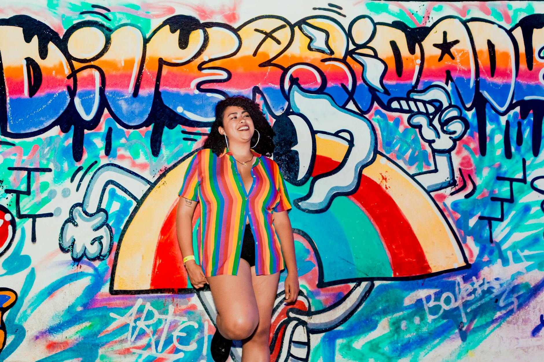 a woman in colorful shirt leaning on the wall
