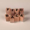 wooden blocks spelling feedback on beige background