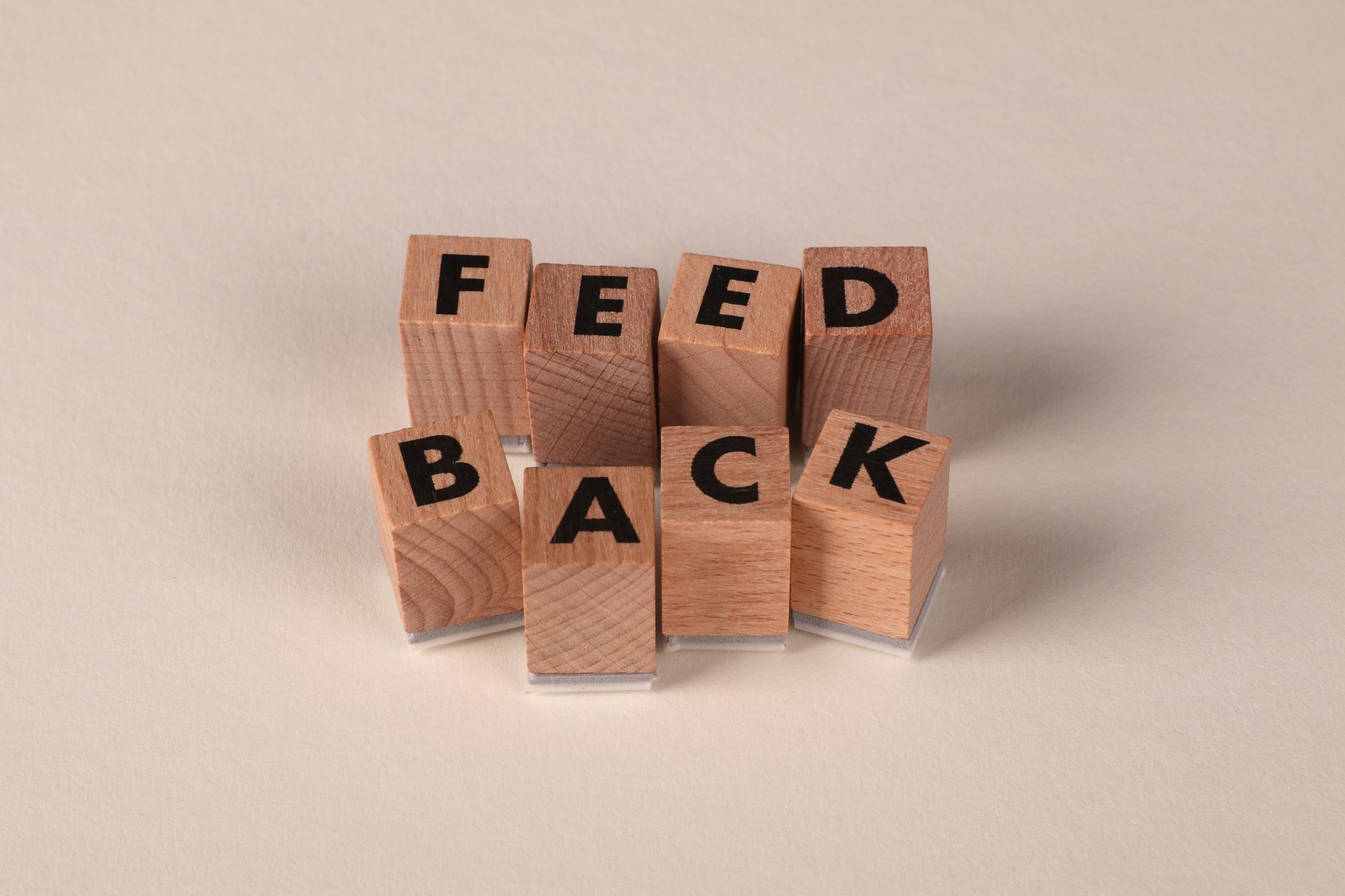wooden blocks spelling feedback on beige background